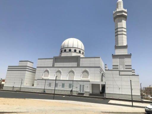 واجهة مسجد مكسوة بكسر الرخام الكريمي مع شرائط رمادية